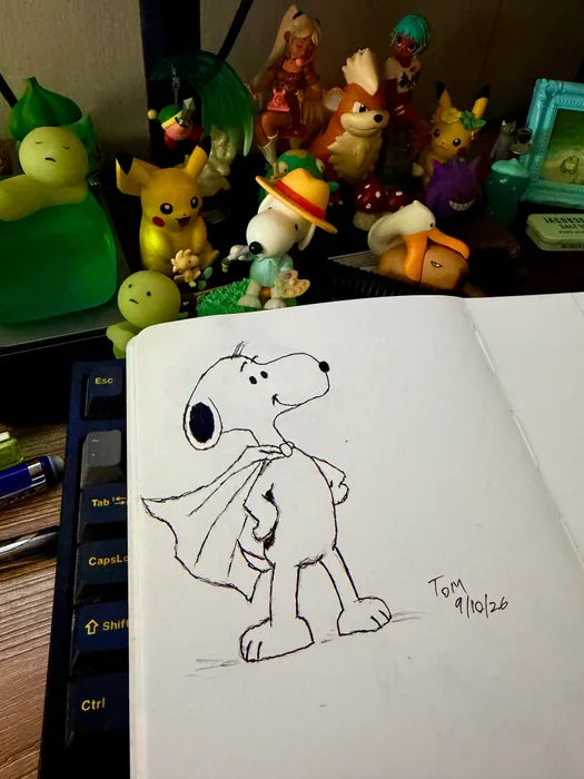Snoopy wearing a cape in a sketchbook drawing.