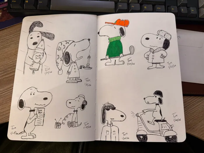A sketchbook spread filled with several Snoopy drawings.