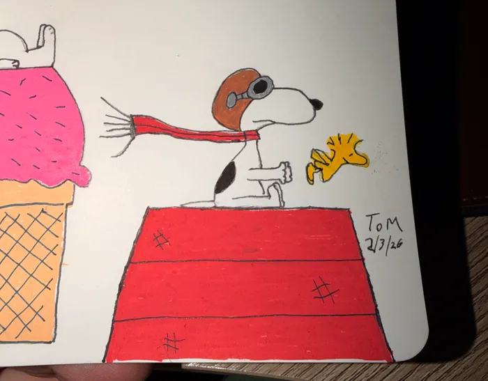 Snoopy in aviator goggles on his doghouse with Woodstock.