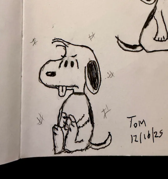 Snoopy with his tongue out in a sketchbook drawing.