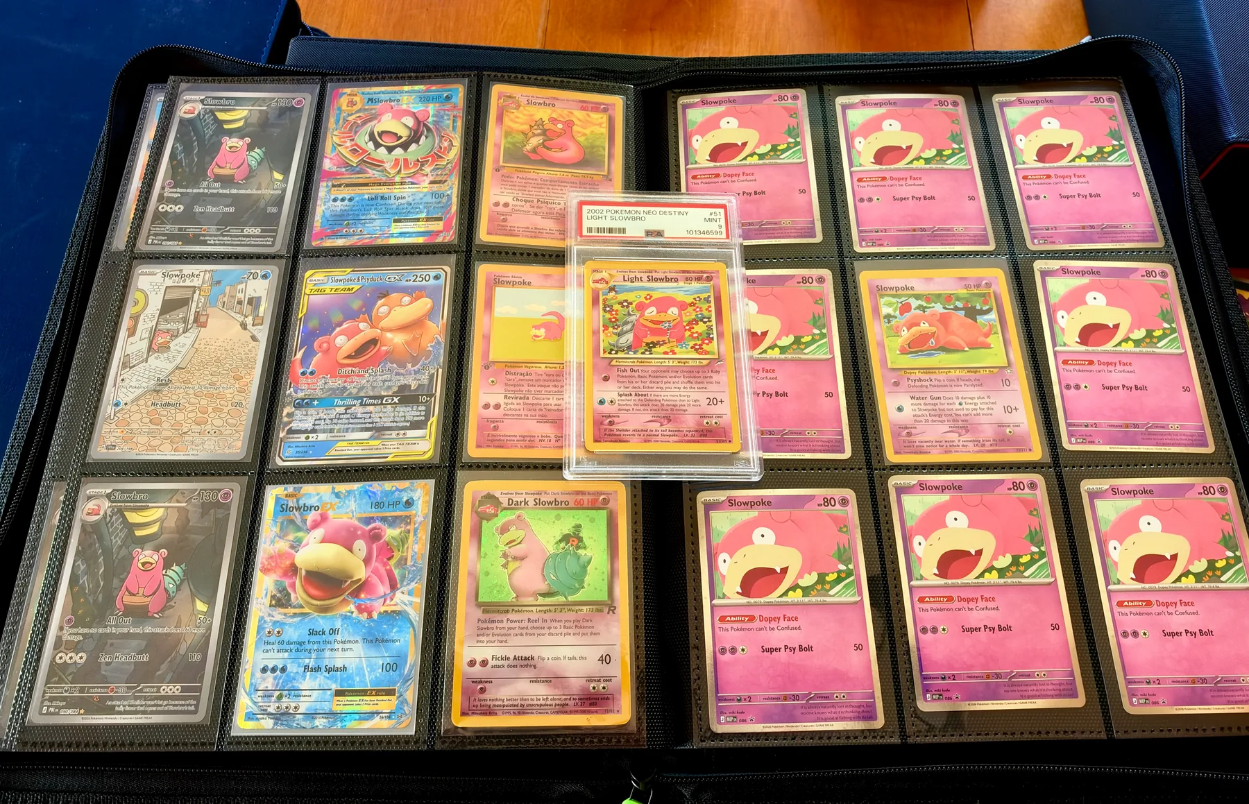 A binder page of Slowpoke and Slowbro cards, with several pink Dopey Face Slowpoke promos and a graded Light Slowbro in the center.